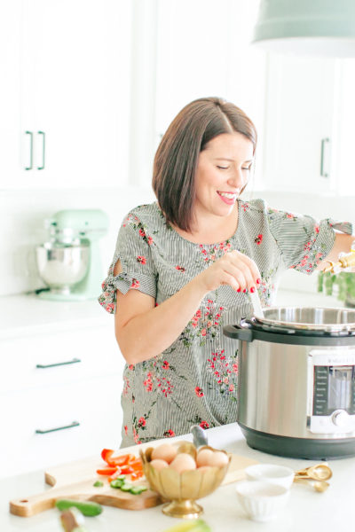woman cooking with ultra instant pot in white kitchen