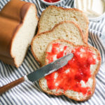 Bread machine gluten free bread with butter and jam with a knife