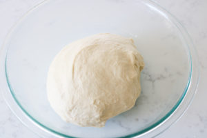 homemade bread dough sitting in a greased bowl