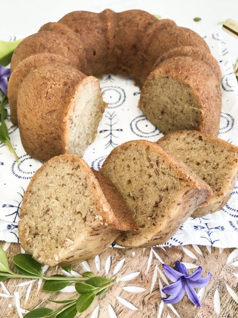 Instant Pot banana bread on a cutting board with floral items