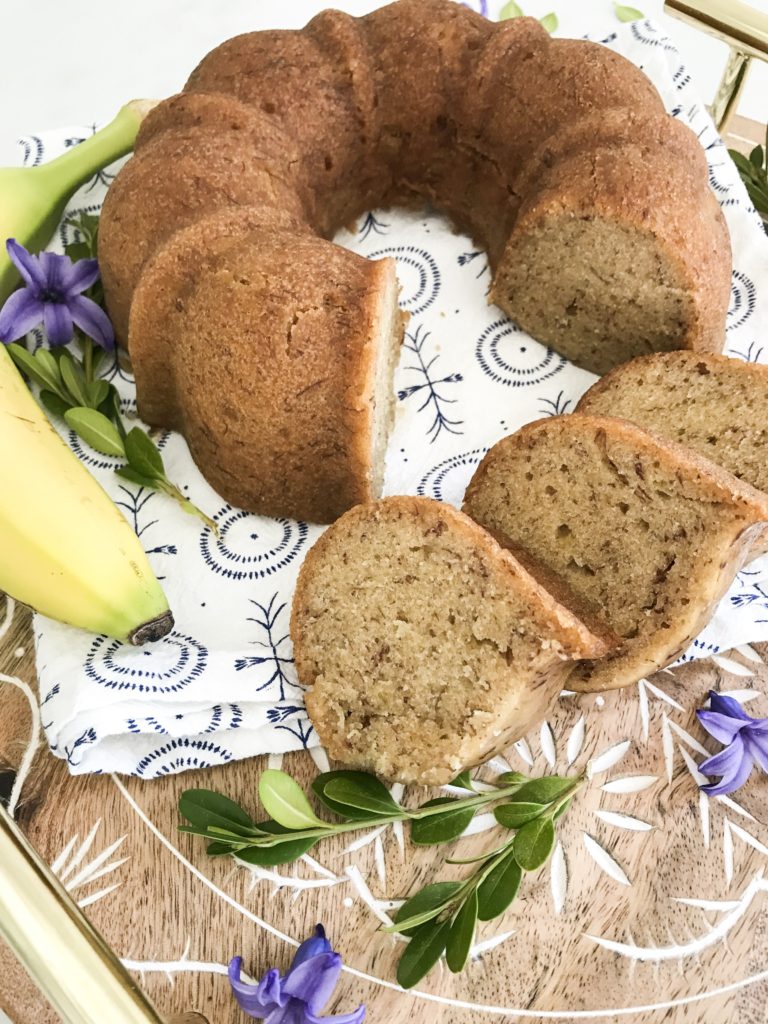 Instant Pot banana bread on a cutting board with floral items
