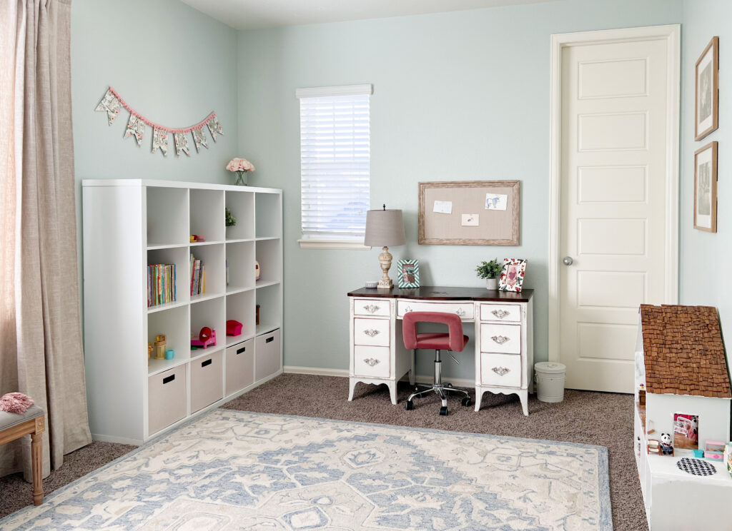 girl bedroom with mint green walls and desk, shelving and white and blue rug