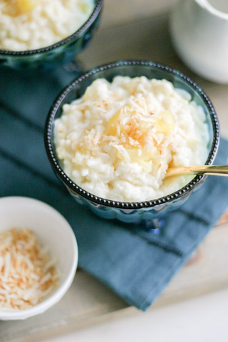 Instant Pot Coconut Pineapple Rice Pudding in a blue dish with spoon